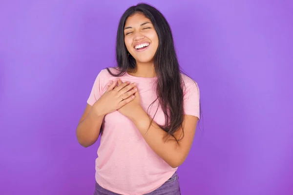 Joven Chica Hispana Con Camiseta Rosa Sobre Fondo Púrpura Mantiene — Foto de Stock