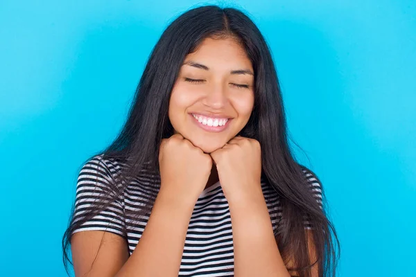 Fröhliches Junges Hispanisches Mädchen Mit Gestreiftem Shirt Vor Blauem Hintergrund — Stockfoto