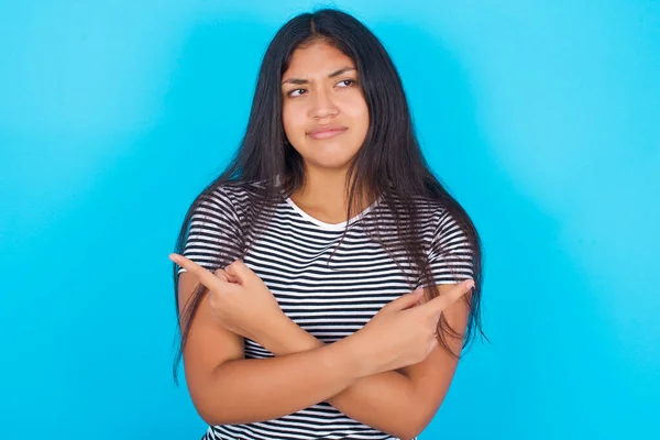 Seriös Ung Latinamerikansk Flicka Bär Randig Shirt Över Blå Bakgrund — Stockfoto