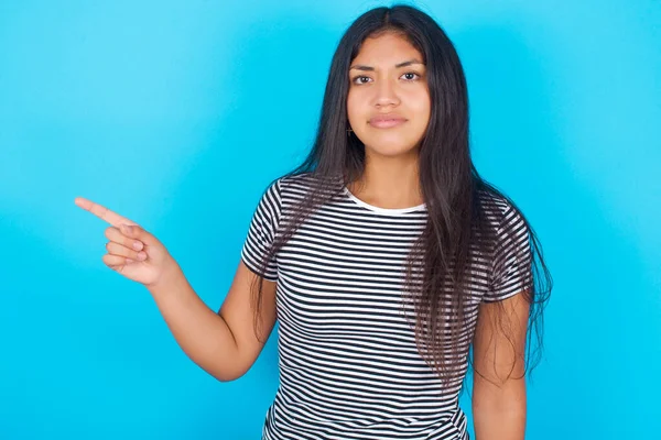 Seriös Ung Latinamerikansk Flicka Bär Randig Shirt Över Blå Bakgrund — Stockfoto