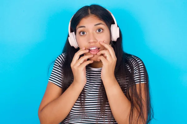Šokovaný Mladý Hispánec Dívka Sobě Pruhované Tričko Přes Modré Pozadí — Stock fotografie
