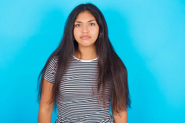 Displeased Young Hispanic Girl Wearing Striped Shirt Blue Background Frowns — Stock Photo, Image