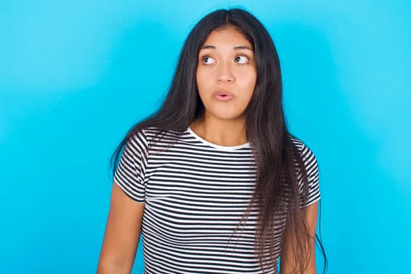 Geschokt Jong Spaans Meisje Draagt Gestreept Shirt Blauwe Achtergrond Kijkend — Stockfoto