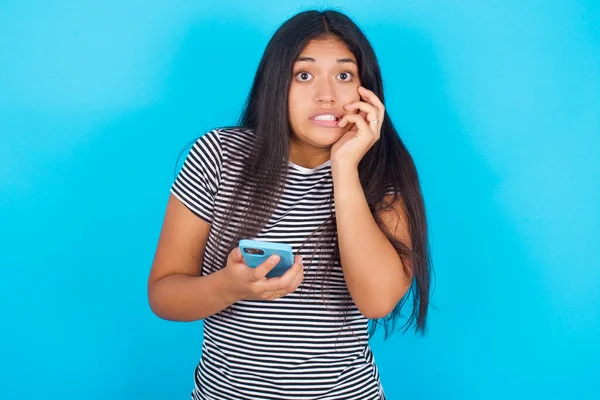 Muchacha Hispana Joven Con Camiseta Rayas Sobre Fondo Azul Sosteniendo — Foto de Stock