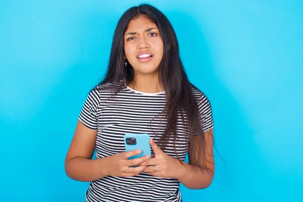 Photo Astonished Young Hispanic Girl Wearing Striped Shirt Blue Background — Stock Photo, Image