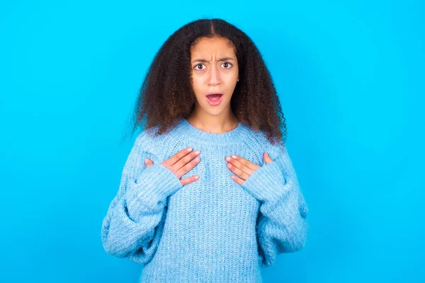 Afroamerikansk Tenåringsjente Med Afrofrisyre Kledd Blå Genser Blå Bakgrunn Holder – stockfoto