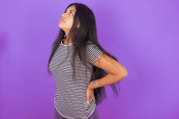 Hispanisches Mädchen Mit Gestreiftem Shirt Vor Lila Hintergrund Bekam Rückenschmerzen — Stockfoto