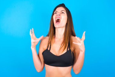 Güzel esmer kadın spor giyer, ağlar ve çığlık atar. İnsani duygular, yüz ifadesi kavramı. Çığlık, nefret, öfke.