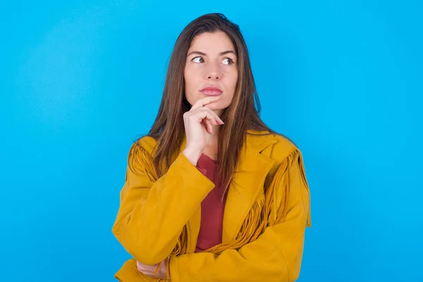 Shot Contemplative Thoughtful Woman Wearing Jacket Blue Studio Background Keeps — Stock Photo, Image