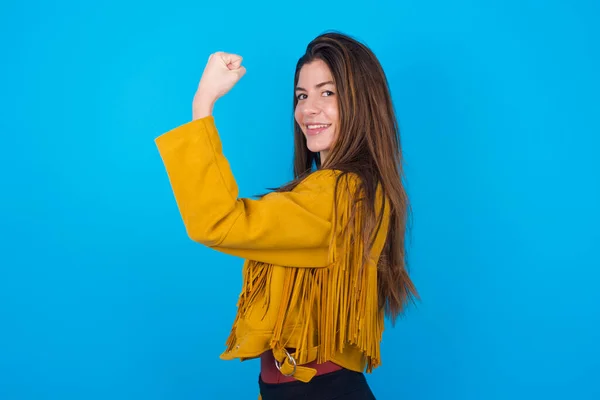 Junge Schöne Frau Jacke Über Blauem Studiohintergrund Die Muskeln Nach — Stockfoto