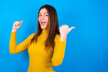 Balıkçı yaka kazak giyen havalı kadın boş yeri işaret ediyor. 