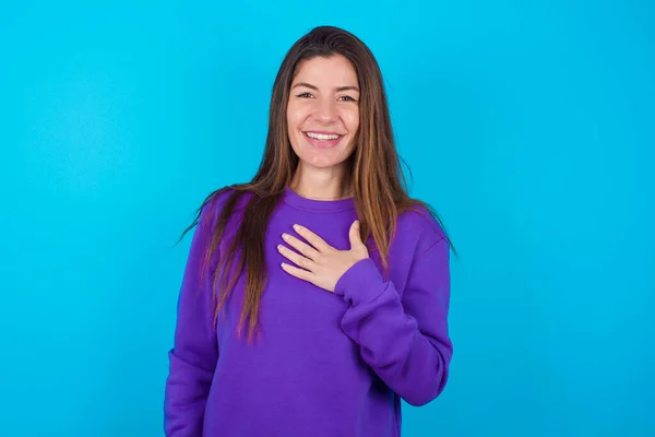 Schöne Frau Die Lila Pullover Über Blauem Studiohintergrund Trägt Lächelt — Stockfoto