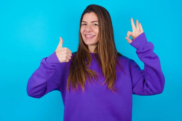 Hermosa Mujer Vistiendo Suéter Púrpura Sobre Fondo Azul Estudio Sonriendo —  Fotos de Stock