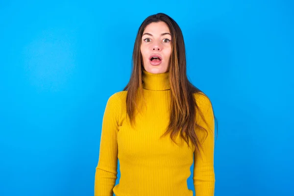 タートルネックセーターのスターを着たショックを受けた女性は 目が開いたまま口を開け 驚いた表情をしています Omgコンセプト — ストック写真