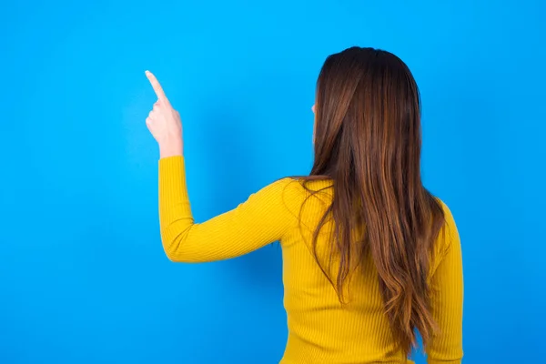 Vrouw Draagt Coltrui Wijzend Naar Kopieerruimte Achteraanzicht Draai — Stockfoto