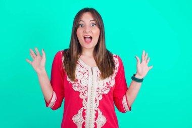 İyimser kadın sevinçten avuçlarını kaldırıyor, birinden müthiş bir hediye aldığı için mutlu, yüksek sesle bağırıyor, heyecanlı model çığlık atıyor..