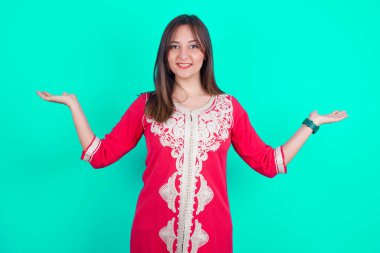 Neşeli, iyimser, güzel, beyaz bir kadın elinde iki avuç dolusu fotokopi alanı tutuyor.