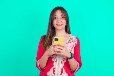 Genç, beyaz, güzel bir kadın uzak iletişimden zevk alıyor. Akıllı telefon kullanıyor, hızlı bir şekilde internette sörf yapıyor.