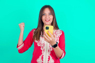 Kafkas 'lı güzel bir kadının portresi. Elinde akıllı bir telefonla kutlama yapıyor.