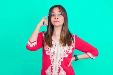 Genç, güzel, beyaz bir kadın bir şeyler ezberlemeye çalışıyor. Parmağını şakağa uzatıyor. Sınav için gerekli bilgileri veriyor.,