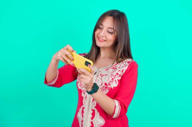 Genç, güzel, beyaz bir kadın el ele tutuşmuş, akıllı telefon kullanıyor, video oyunları oynuyor ya da sohbet ediyor.