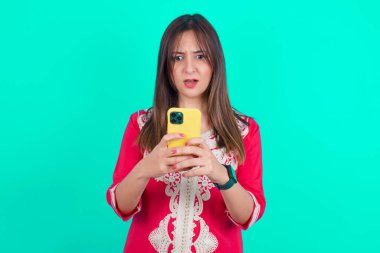 Sosyal medya haberlerini ya da önemli e-postaları okuyarak akıllı telefon kullanan odaklanmış beyaz bir kadın.