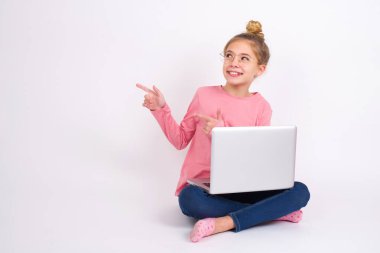 İyimser kız iki eliyle işaret ediyor ve boş alana bakıyor..