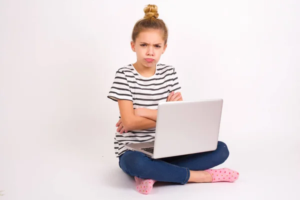 悲観的な不満美しいですCaucasianティーン女の子座っていますノートパソコンで蓮の位置の上に白い背景ルックスとともに悲惨な表現でカメラから額 作る不幸な優雅 — ストック写真