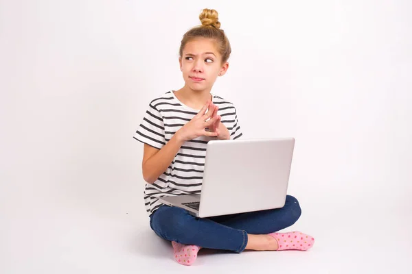 漂亮的高加索少女坐在膝上型笔记本电脑上 白色背景 尖尖的手指上 神色神秘 旁若无人 心怀鬼胎 — 图库照片