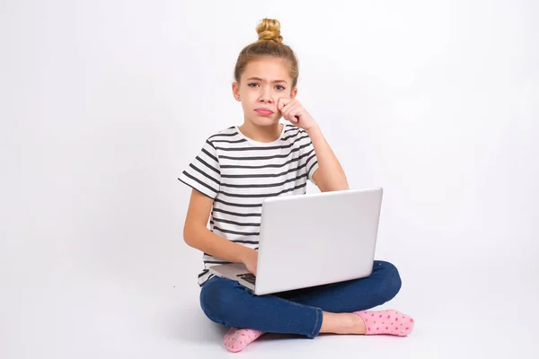 落胆した美しい白地に蓮の花の位置にノートパソコンで座っている白地の十代の少女は 悲観的な表情で強調涙が立っています 負の感情 — ストック写真