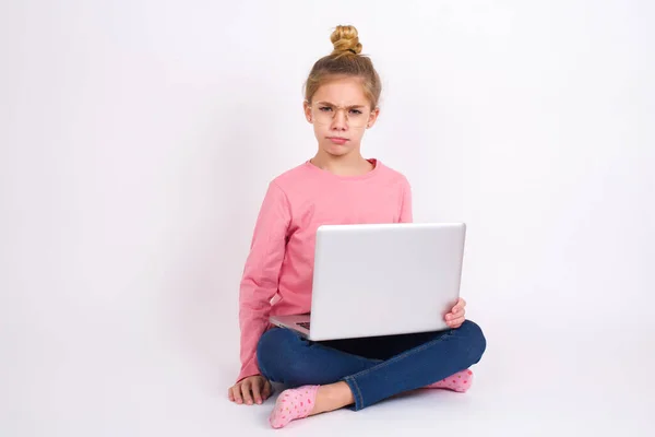 美しいですCaucasianティーン女の子座っていますノートパソコンで蓮の位置にホワイトバックグランド上の指で下に示す広告 驚きの顔とオープン口 — ストック写真