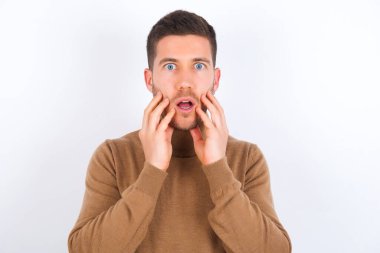 Dilsiz adam ellerini açık tutuyor. Ağzı açık. Şok edici haberlere tepki veriyor.