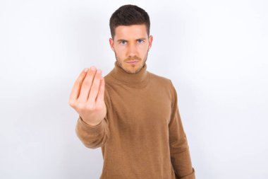 Genç beyaz adam İtalyanca jest yapıyor. Elleri ve parmakları kendinden emin ifade ediyor.