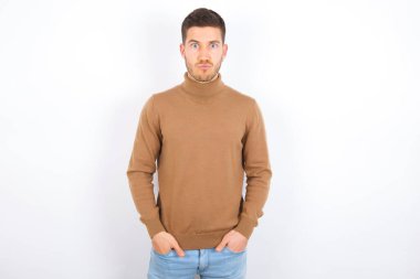 Beyaz arka plan üzerine balıkçı yaka giyen sevimli, komik beyaz bir adamın portresi.