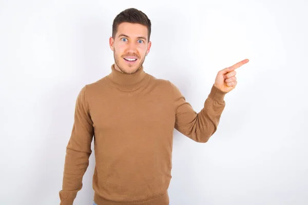 Young Caucasian Man Wearing Turtleneck White Background Points Aside Copy — Stock Photo, Image