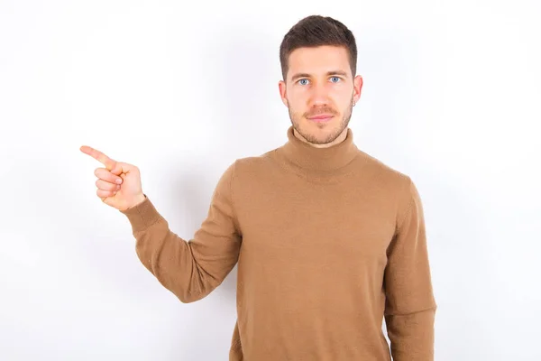 Young Caucasian Man Wearing Turtleneck White Background Points Side Blank — Stock Photo, Image