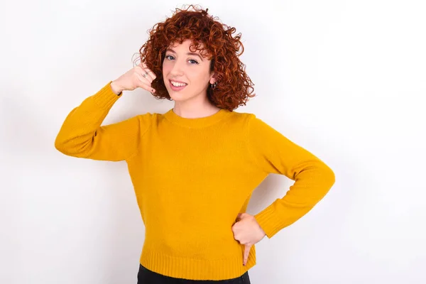 Jong Roodharig Meisje Draagt Gele Trui Witte Achtergrond Imiteert Telefoongesprek — Stockfoto