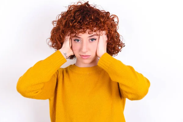 Frustrada Joven Pelirroja Con Suéter Amarillo Sobre Fondo Blanco Tapando —  Fotos de Stock