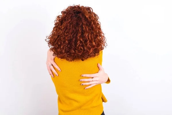 Joven Pelirroja Vistiendo Suéter Amarillo Sobre Fondo Blanco Abrazándose Feliz — Foto de Stock