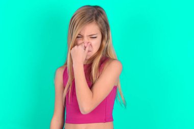 Küçük beyaz kız kötü bir koku yüzünden burnu tutuyor..