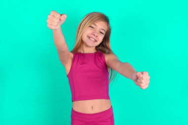 Kafkasyalı küçük sevimli bir kızın portresi, ellerini başının üstünde tutarken geniş bir gülümseme. Güven ve rahatlama kavramı.