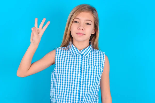 小さな白人少女は自信を持って幸せに微笑んでいる間指番号3を示し 指を指で指を指さす — ストック写真