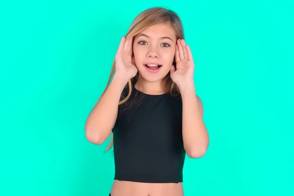Blondes Kleines Kind Mädchen Trägt Schwarze Sportkleidung Über Grünem Hintergrund — Stockfoto