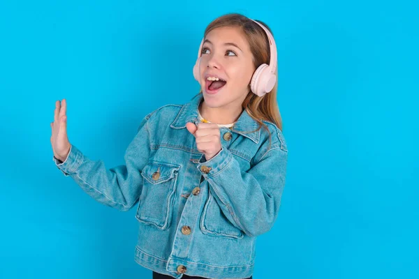 Feliz Niña Rubia Con Chaqueta Mezclilla Sobre Fondo Azul Canta —  Fotos de Stock