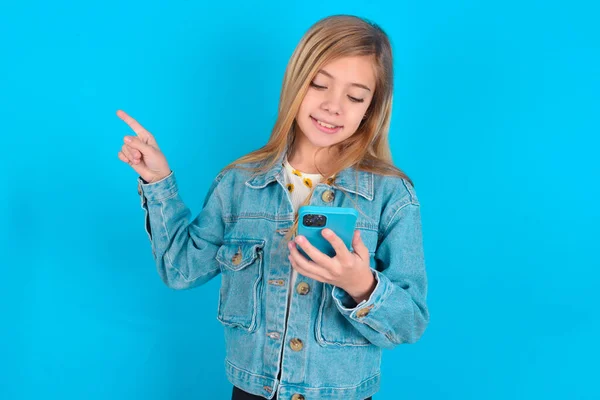 Sorrindo Pequena Menina Branca Apontando Dedo Para Espaço Branco Segurando — Fotografia de Stock