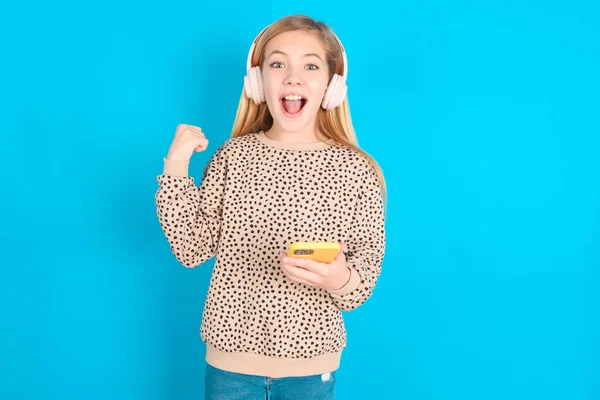 Pozitivní Běloška Dívka Drží Moderní Mobilní Telefon Připojen Sluchátkům Sevře — Stock fotografie