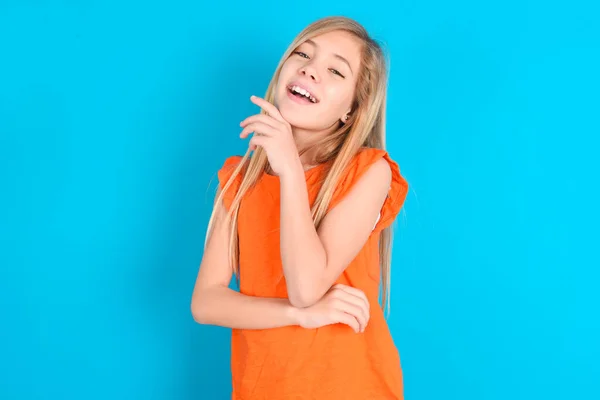 Liten Flicka Bär Orange Shirt Över Blå Bakgrund Skrattar Glatt — Stockfoto
