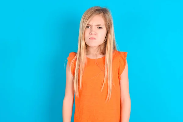 Ofendido Menina Criança Insatisfeita Vestindo Camiseta Laranja Sobre Fundo Azul — Fotografia de Stock