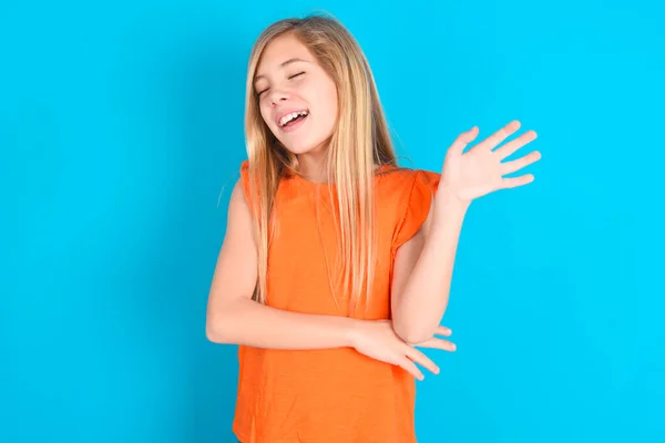 Overblij Succesvolle Kleine Meisje Dragen Oranje Shirt Blauwe Achtergrond Verhoogt — Stockfoto