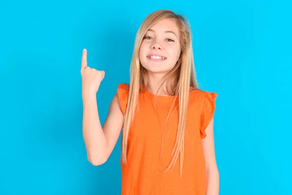 Menina Criança Vestindo Camiseta Laranja Sobre Fundo Azul Sorrindo Olhando — Fotografia de Stock